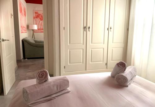 a room with white cabinets and two towels on a bed at Ritual Sevilla Suites Alameda 1 in Seville