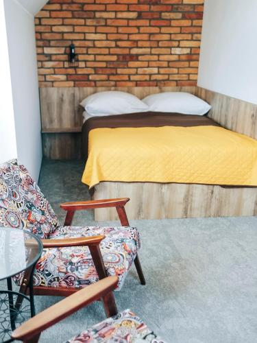 a bedroom with a bed and chairs and a brick wall at Kaszubskie Zacisze in Władysławowo