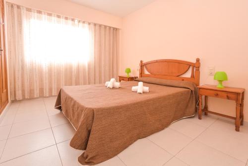 1 dormitorio con 1 cama con 2 toallas en Apartamentos Marblau Las Alondras-Julio y Agosto SOLO FAMILIAS, en Gandía