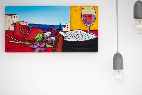 a painting of a book and a glass of wine at Mon hotel in Ciutadella