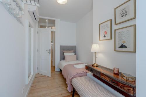 ein weißes Schlafzimmer mit einem Bett und einem Tisch in der Unterkunft Príncipe Real Flamingo Residence in Lissabon