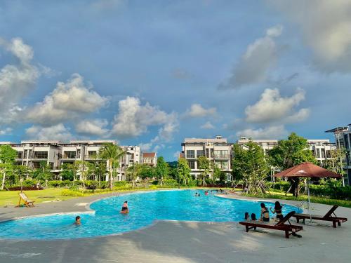 una grande piscina in un resort con gente dentro di Minimalist & Modern Apartment I a Phu Quoc