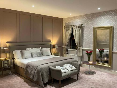 a bedroom with a bed and a chair and a mirror at Ballyliffin TownHouse Boutique Hotel in Ballyliffin