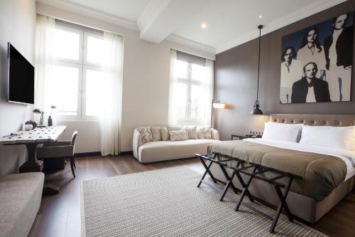 ein Schlafzimmer mit einem Bett, einem Tisch und einem Sofa in der Unterkunft Quentin XL Potsdamer Platz in Berlin