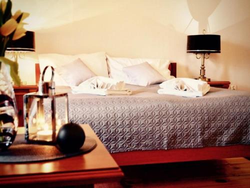 a bedroom with a large bed with white pillows and a table at Zamek Otmuchów in Otmuchów