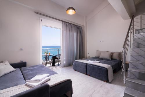 a hotel room with two beds and a balcony at Xenia Suites in Limenaria