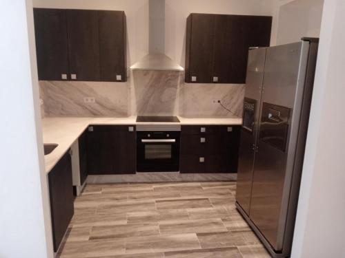 una cocina con electrodomésticos de acero inoxidable y armarios marrones en Casa Brava, en Alicante