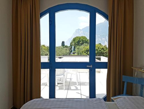 a bedroom with a window with a view of a mountain at Casa Sandra Bertolini Alla Spiaggia in Nago-Torbole