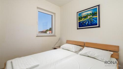 1 cama en un dormitorio con una foto en la pared en Rona Apartment Andy en Novalja