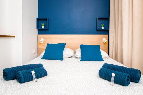 - un lit avec des murs bleus et des oreillers bleus dans l'établissement Le Blue Bird - Hypercentre - Gare - ToulouseCozyFlat, à Toulouse