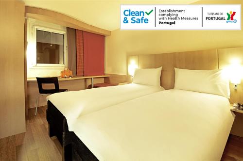 a large white bed in a hotel room at ibis Porto Centro São Bento in Porto