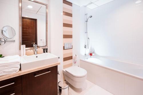a bathroom with a toilet and a sink and a mirror at Elite Royal Apartment - Onyx in Dubai