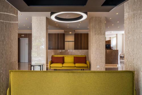 a lobby with a yellow couch in a room at Hotel Girassol - Suite Hotel in Funchal