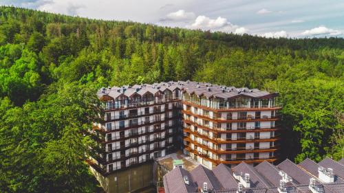 eine Luftansicht eines Gebäudes inmitten eines Waldes in der Unterkunft Apartamenty Sun & Snow Resorts II in Szklarska Poręba