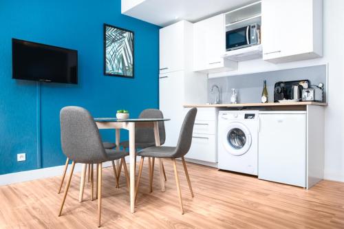 une cuisine et une salle à manger avec une table et des chaises dans l'établissement Le Blue Bird - Hypercentre - Gare - ToulouseCozyFlat, à Toulouse