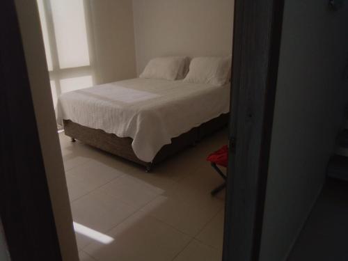a bedroom with a bed with white sheets and pillows at Casa en Santa Veronica Atlantico in Santa Veronica