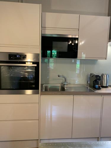 a kitchen with a sink and a microwave at Ty Carreg Fach Staycation Cottage Cardiff in Cardiff