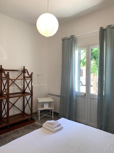 een slaapkamer met een bed, een lamp en een raam bij Casa Nica in Mondello
