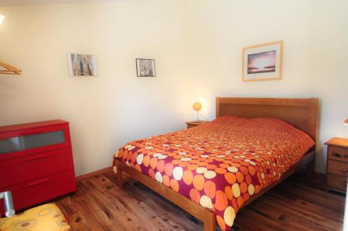 a bedroom with a bed and a red dresser at Casa da fonte in Salir de Porto