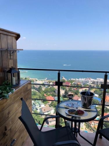 a table and chairs on a balcony with a view of the ocean at Arcadia apartment & sea terrace in Odesa