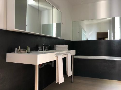 a bathroom with a white sink and a mirror at Le Pré du Moulin - Maison Alonso - Hôtel & Restaurant in Sérignan-du-Comtat