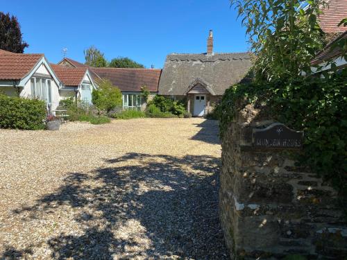 a stone sign in front of a house at Munden House in Sherborne