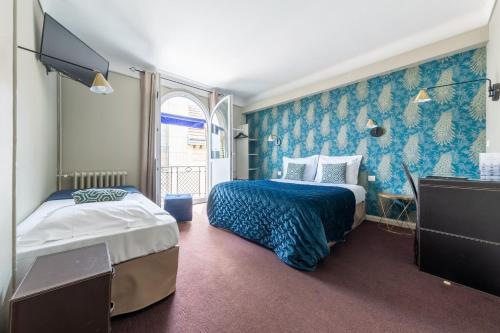 Cette chambre comprend 2 lits et une télévision. dans l'établissement Hôtel Azur, à Reims