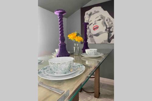 een tafel met borden en bekers en een foto van een vrouw bij The Regency Apartments in Brighton & Hove