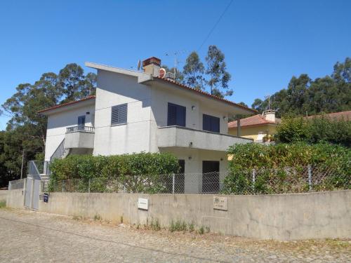 ein weißes Haus mit einem Zaun davor in der Unterkunft Casa Da Veiga in Caminha