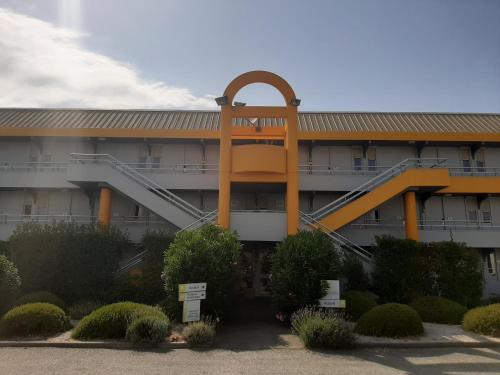 a building with a spiral staircase in front of it at Premiere Classe Carcassonne in Carcassonne