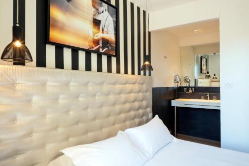 a bedroom with a large bed and a sink at Le Pré du Moulin - Maison Alonso - Hôtel & Restaurant in Sérignan-du-Comtat