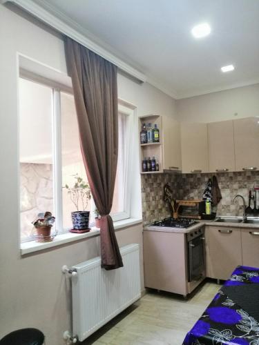 a kitchen with a stove and a window at Guesthouse different in Tbilisi City