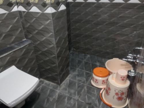 a small bathroom with a toilet and a sink at hotel restandride in Anand