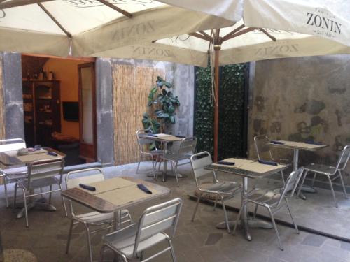 un restaurante con mesas, sillas y sombrillas en Hotel Filippeschi, en Orvieto