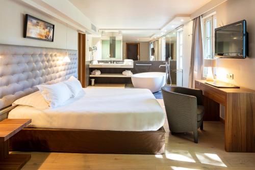 ein Hotelzimmer mit einem Bett und einem Bad in der Unterkunft Le Pré du Moulin - Maison Alonso - Hôtel & Restaurant in Sérignan-du-Comtat