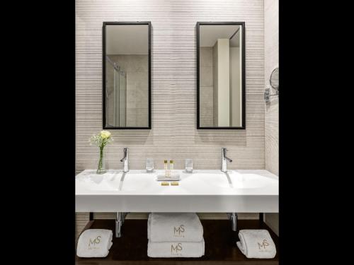 uma casa de banho com dois lavatórios e dois espelhos em Hotel Moon & Sun Porto no Porto