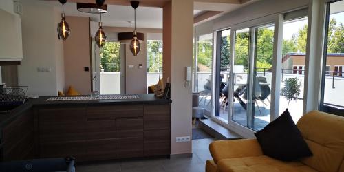 a living room with a couch and some windows at LAKE MOMENTS - Emerald Penthouse in Balatonszemes