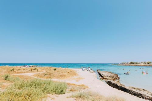 a beach with a bunch of people in the water at Miramare Blue Stay in Torre Santa Sabina