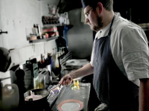 a man preparing a dish in a kitchen at La Fosse at Cranborne in Cranborne