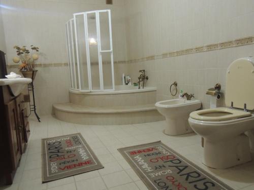 ein Badezimmer mit Toilette, Badewanne und Waschbecken in der Unterkunft Casa da Praia das Paredes-Nazaré in Senhora da Vitória