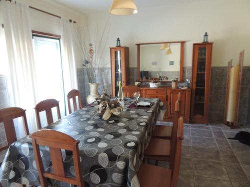 a dining room with a table with chairs and a mirror at Paredes da Vitória in Senhora da Vitória