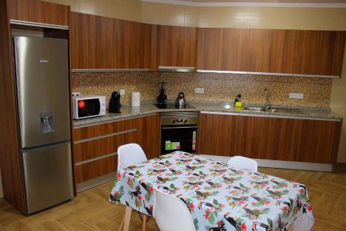 La cuisine est équipée d'une table, de chaises et d'un réfrigérateur. dans l'établissement Casa Pôr do Sol, à Ginetes