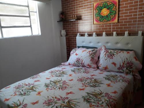 a bedroom with a bed and a brick wall at Pertinho da Mata in Cachoeiras de Macacu