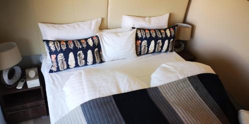 a bed with pillows on it in a room at LAKE MOMENTS - Emerald Penthouse in Balatonszemes