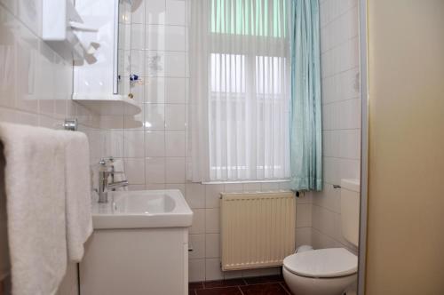 a white bathroom with a sink and a toilet at Hotel An der Kapelle in Meiningen