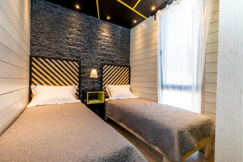 two beds in a room with a brick wall at Living Point Mobile Homes in Mali Lošinj