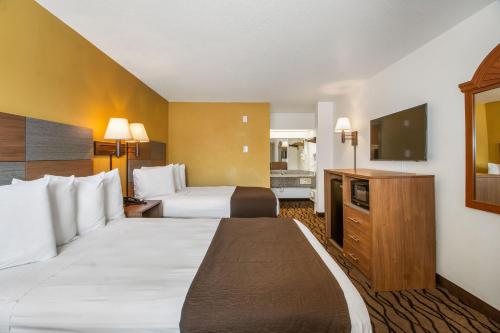 Habitación de hotel con 2 camas y TV de pantalla plana. en Motel 6 Galveston, TX Seawall, en Galveston