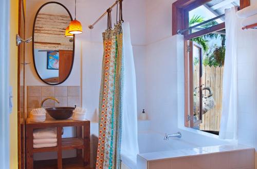 a bathroom with a tub and a sink and a mirror at Key West Bed and Breakfast in Key West