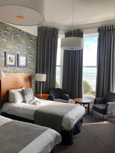 a hotel room with two beds and a couch and chairs at West Rocks Townhouse in Eastbourne