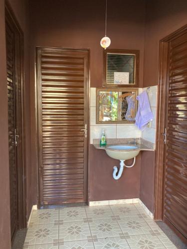 baño con lavabo y ventana en Zizi Home, en Chapada dos Guimarães